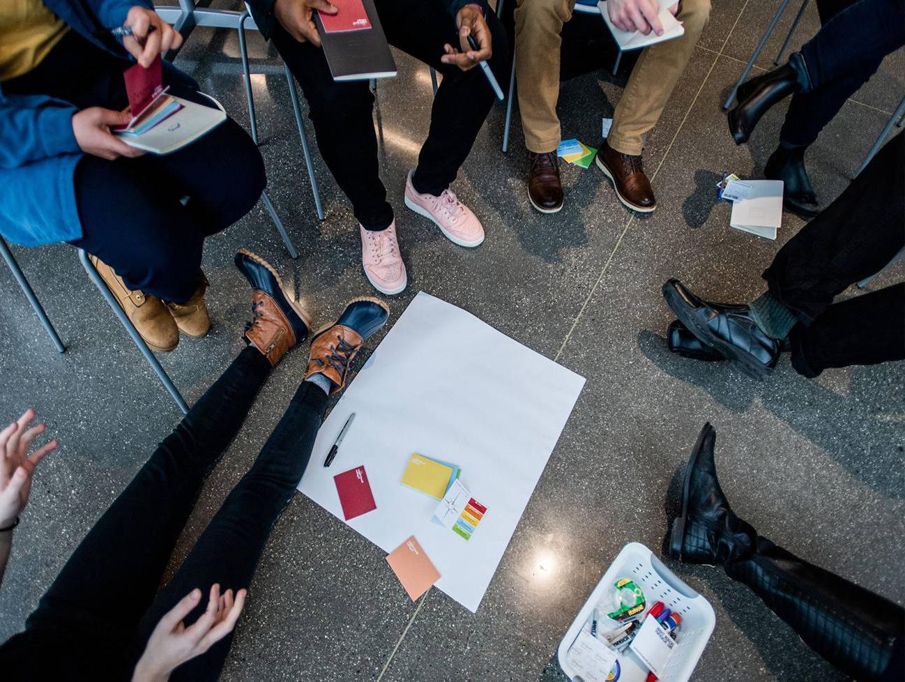 people standing in circle for design-based workshop